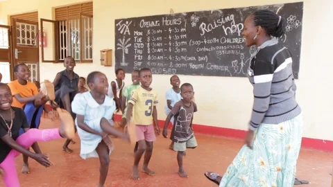 A Ugandan teacher doing physical execrices and games with children. Stock Footage 104265558