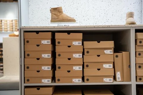 UGG Classic Mini boots displayed above stacked boxes. Toronto, Canada - July 13, Stock Photos