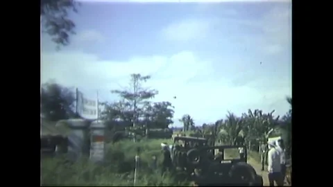 UH-1D helicopter flies over a village and drops leaflets - 1966 Stock Footage 91261776