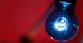 UHD 4K Blue Bulb Lamp Illuminating Artificial Light Closeup Red Background Lit 4k or 4k+ Resolution