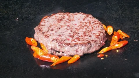 UHD closeup shot of the beef burger being fried with red peppers Видео 102755282