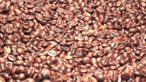 UHD closeup shot of the dark roasted coffee beans on a turntable Stockbeeldmateriaal 104140888