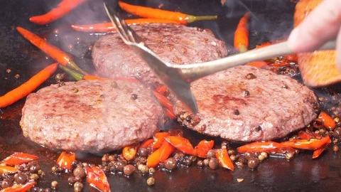 UHD closeup shot of the delicious beef burgers are frying on the hot iron Video stock 101470145