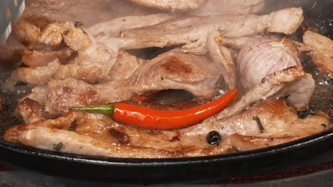 UHD closeup shot of the delicious pork bellies frying with peppers and herbs Video stock 98162853