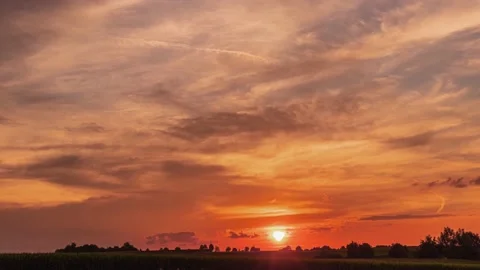 UHD. Dramatic time lapse panorama of orange sunset with dark flying clouds Stock Footage 204873844