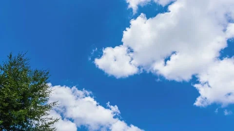 UHD. Time lapse of white swirling clouds flying across the blue sky Stock Footage 204874571