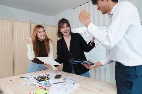 UI designer and UX developer brainstorm celebrate together after meeting success Stock Photos