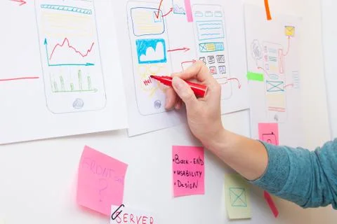 Ui designer drawing on paper structure of app interface. Foto stock