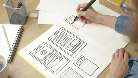 UI designer sketches the user interface of a web application for a mobile phone. Stock Footage 205923168