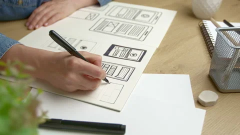 UI designer sketches the user interface of a web application for a mobile phone. Stock Footage 205929907