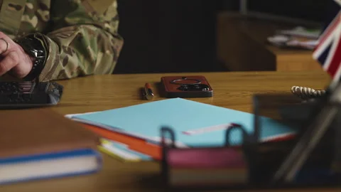U.K. army general typing on computer in command center, controlling mission Stock Footage 335537292