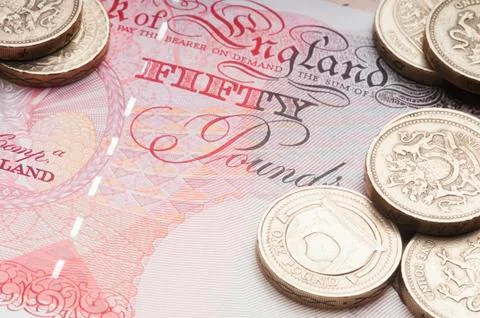 UK coin currency stack sitting on Fifty Pound Note. 스톡 사진