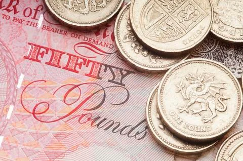 UK coin currency stack sitting on Fifty Pound Note. Stock Photos