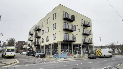 UK: Developer builds balcony at block of flats around street lamppost 스톡 동영상 291195616