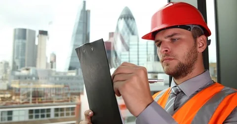 UK Engineer Man Taking Notes on Clipboard Examine Construction Development Area Stock Footage 70650243