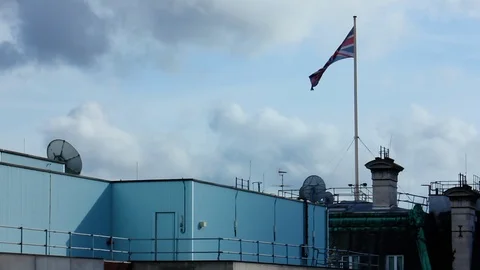 A UK Flag flies over a merging of Traditional and Modern Roofs Stock Footage 89544282