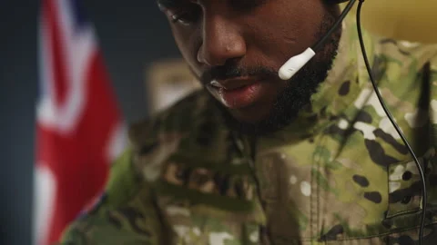 U.K. intelligence officer in headset coordinates tactical operation from office Stock Footage 342148986
