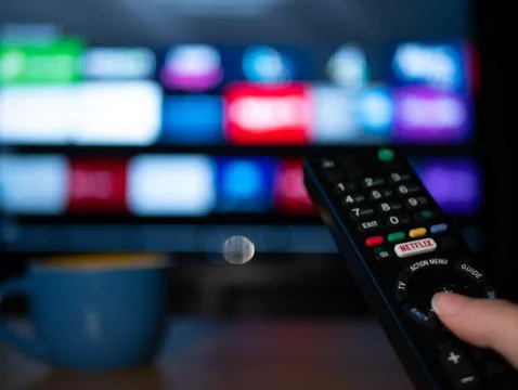 UK, Jan 2020: Netflix remote control with android apps on smart TV screen Stock Photos
