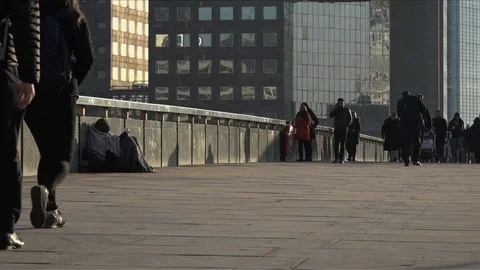 UK January 2017 - A homeless man sits huddled under a blanket as pedestrians Stock Footage