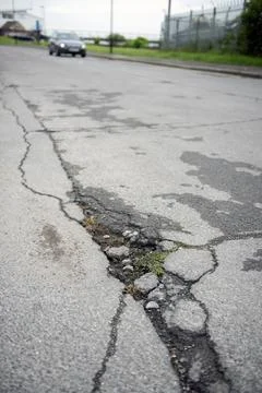UK patchwork roads potholes, and recent repairs already falling apart. Stock Photos