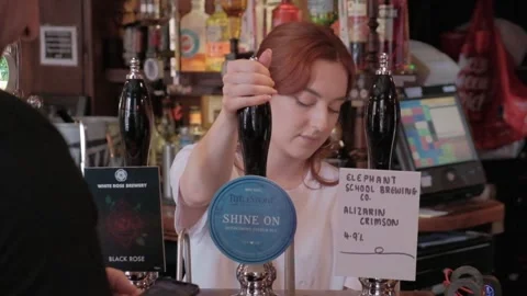 UK pub setting, woman pulling pints, people. Hull.UK.6.7.2024 Stock Footage 280461731
