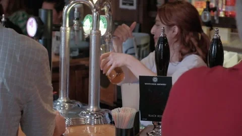 UK pub setting, woman pulling pints, people. Hull.UK.6.7.2024 Stock Footage 280462693