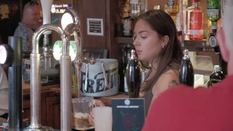 UK pub setting, woman pulling pints, people. Hull.UK.6.7.2024 Stock Footage 280462758