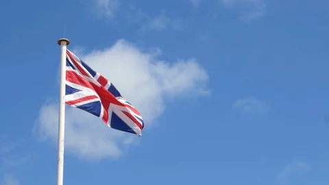 UK Union Flag, slow motion against blue sky Stock Footage 114970123