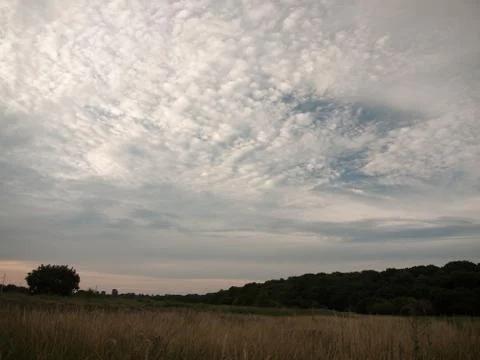 Uk white clouded sky over field with sunset light Stock Photos