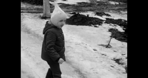 Ukraine - circa 1970s: Soviet child in winter coat and hat playing in the snow Stock-Footage 337462782