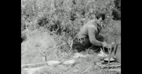 Ukraine - circa 1970s: Soviet man cooking food on a campfire in the forest Stockbeeldmateriaal 325907667