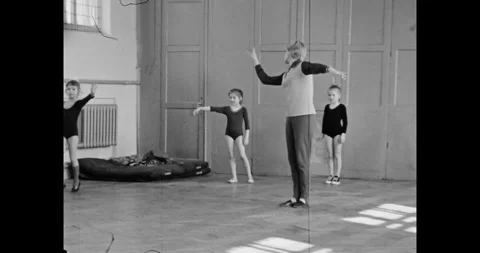 Ukraine - circa 1980s: Instructor Teaching Gymnastics to a Group of Young Girls 動画素材 323297186
