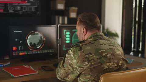 Ukraine intelligence officer tracking threats across multiple screens in office Stock Footage 333307179
