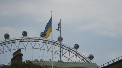 Ukrainian and British flags mounted on top of a building. Video stock 212493989