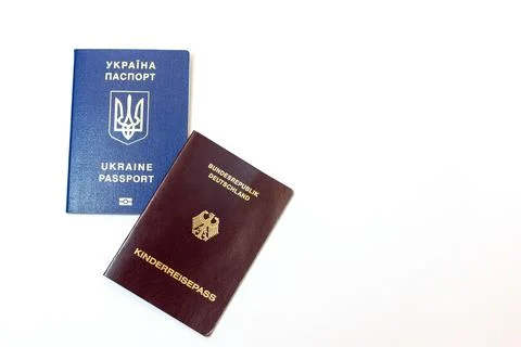 Ukrainian and German passports placed side by side on a clean white surface Stock Photos