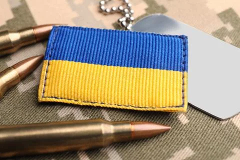 Ukrainian army patch, bullets and ID tags on military camouflage, closeup Stock Photos