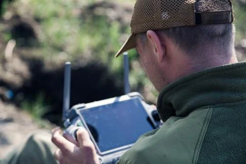 Ukrainian drone operator holding remote controller outdoors Фото