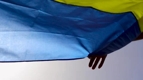 Ukrainian Flag in Hands Against the Sky, Slow Motion. Ukrainian Victory. Stock Footage 246382987