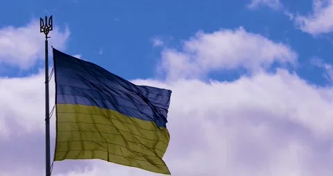 Ukrainian flag with a trident develops in the blue sky with clouds. War in U Stock Footage 201459062