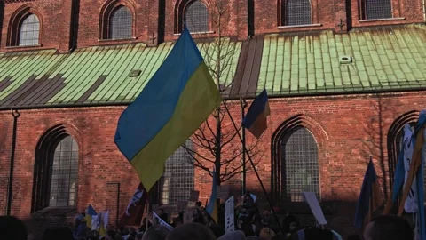 Ukrainian Flag waving in front of crowd and church Stock Footage 171190881