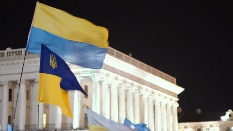 Ukrainian flags on Independence Square in Kiev at night against a white building Stock Footage 120197344