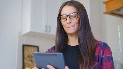 Ukrainian girl using tablet computer to read e-book online in 4k video Video stock 229691661