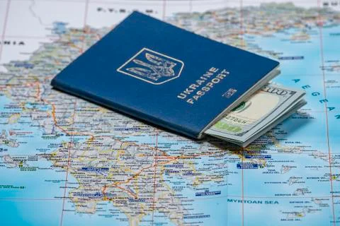 Ukrainian passport with dollars on a map background. emigration kit for earni Stock Photos