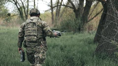 Ukrainian pilot in full gear and body armor, carrying a reconnaissance drone Stock Footage 343507597