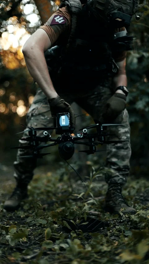 A Ukrainian pilot in full gear and body armor, with an FPV strike drone Stock Footage 345091503