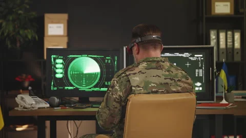 Ukrainian pilot in headset flying FPV drone carrying payload in command hub Stock Footage 335539249