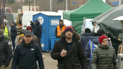 Ukrainian refugees mill around a temporary relief camp, finding refuge in Stock Footage 185989477