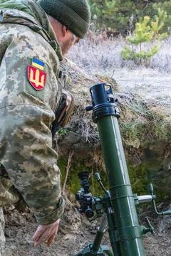 Ukrainian soldier aiming mortar sight in trench Stock Photos