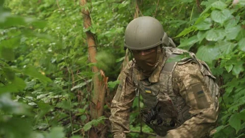 Ukrainian soldier hides from enemy attack in the forest. Stock Footage 201650426