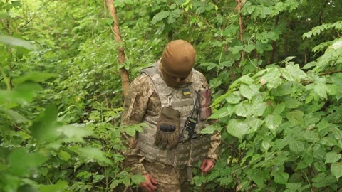 Ukrainian soldier hides from enemy attack in the forest. Stock Footage 201650474